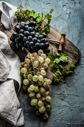 Top view of grapes on board with wine opener