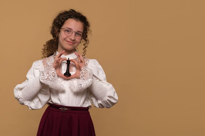 Teen girl holding black chess piece