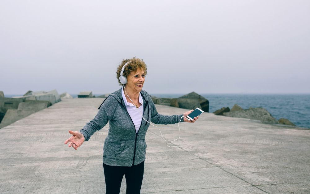 Older woman with headphones and smartphone
