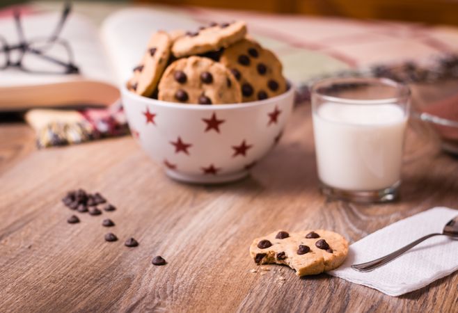 Chocolate chip cookies and milk on wood background