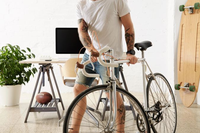 Bearded tattoooed man in blank t-shirt with bicycle