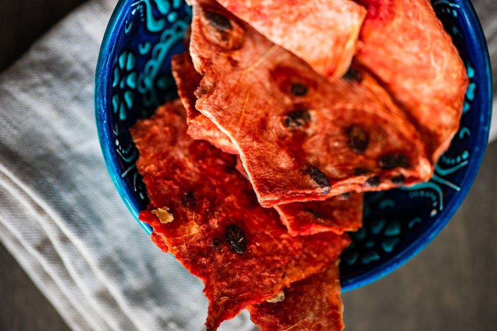 Close up of bowl full of thin slices of dried watermelon