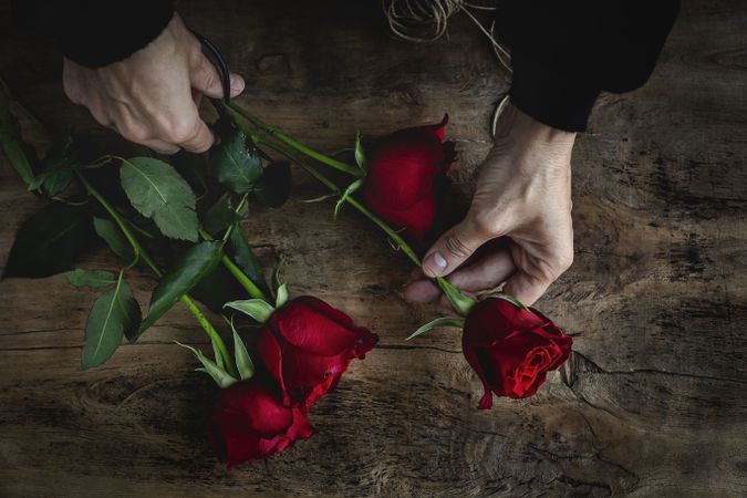 Unrecognizable woman making a bouquet of red roses