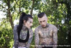 Young edgy white couple covered in full body tattoos posing with tough scowl 426ry4