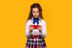 Girl using red smartphone, focused expression