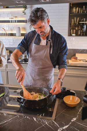 Adult man cooking dinner in kitchen
