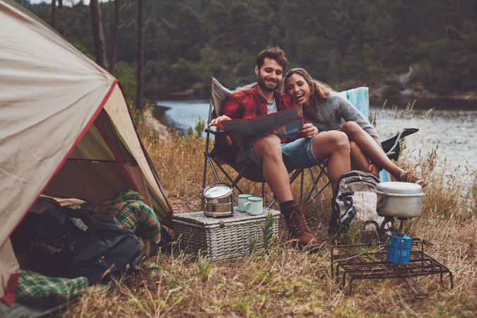 Happy young couple camping next to the lake