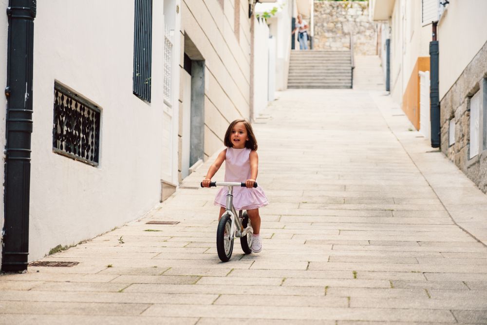 Girl riding on bicycle in narrow street