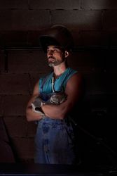 Confident man in welding helmet with arms crossed