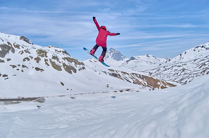 Unrecognizable snowboarder jumping on slope