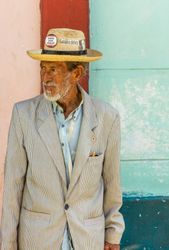 Havana, Cuba - November, 22 2012: Older male in hat on colorful background