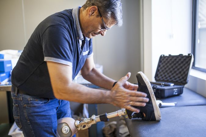 man fixing a prosthesis in a workshop