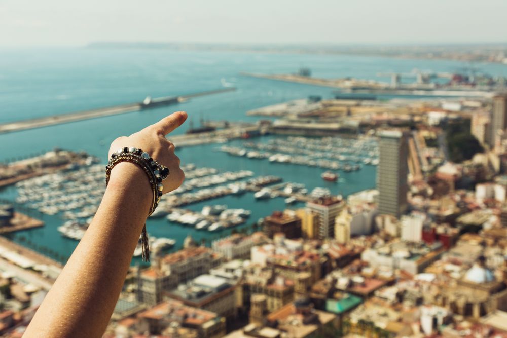 Hand pointing at sights of amazing coast