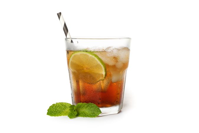Glass of cold cola with lime isolated on blank background