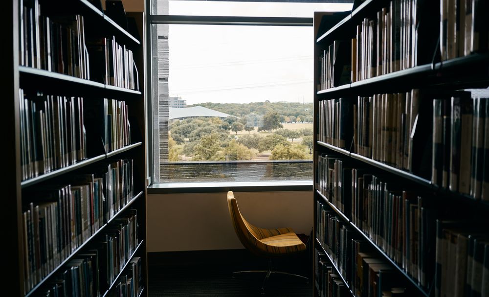 Empty passage between bookcases with big window