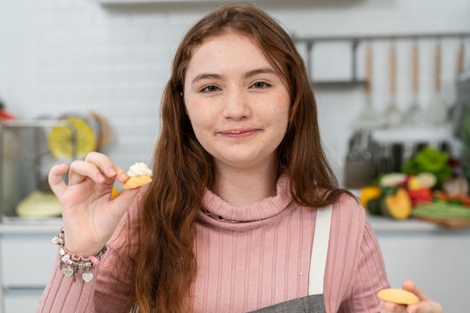 Portrait of girl with cookie in kitchen