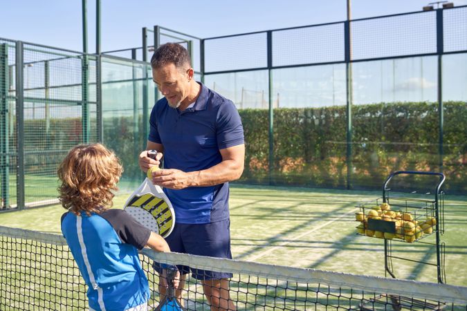 Trainer talking to boy during padel training