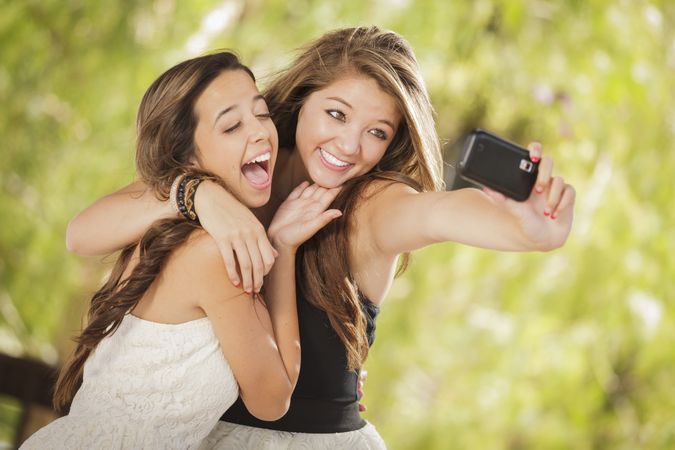 Two laughing female friends in outside garden