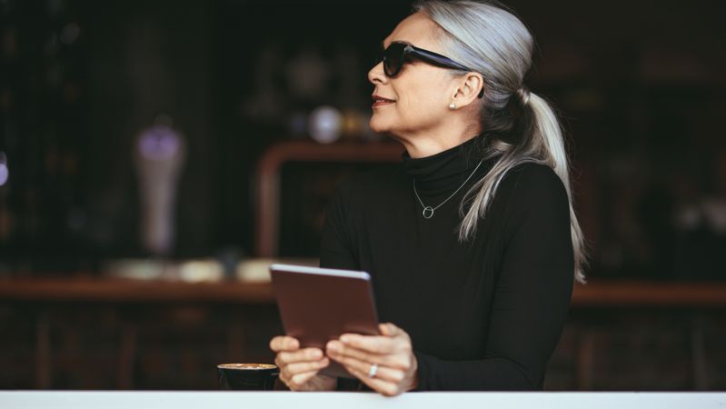 Mature woman at a coffee shop with tablet