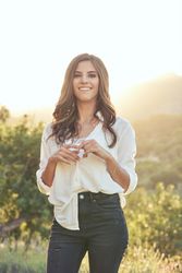 Smiling woman standing in meadow on sunny day