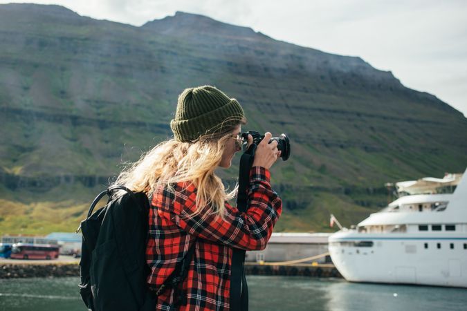 Female photographer take picture of cruise ship in the bay