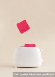Pink toast popping out of toaster on a soft bright beige background 4A7Xz0