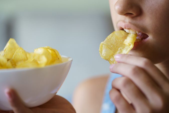 Teenager munching on potato chips