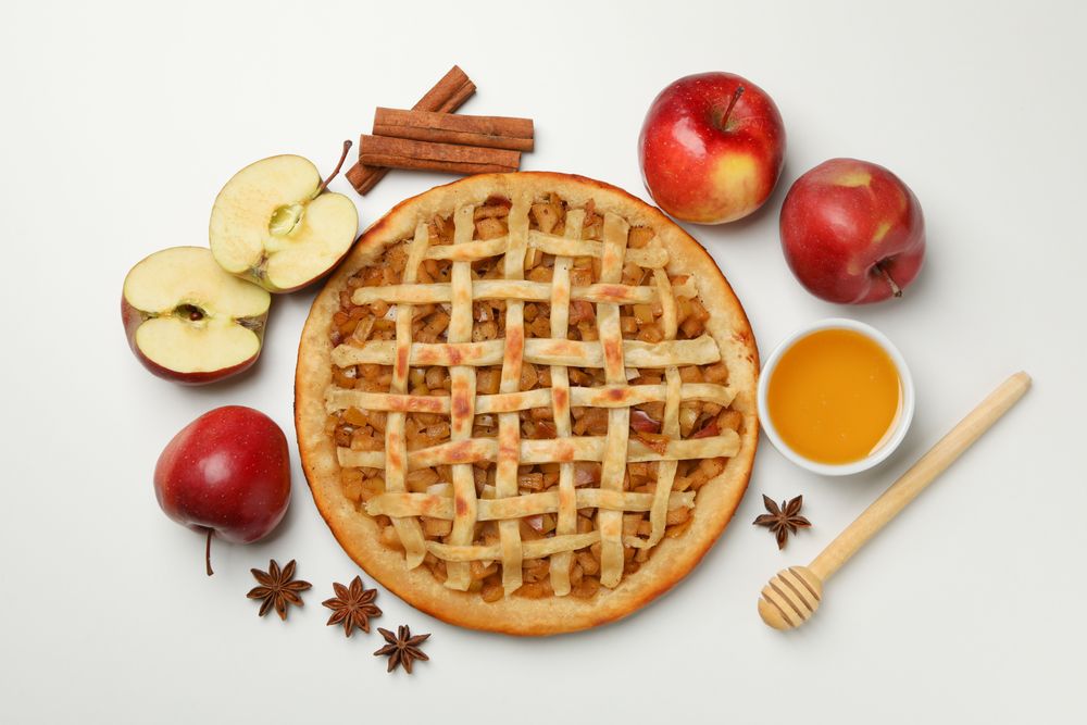 Composition with tasty apple pie on blank background, top view