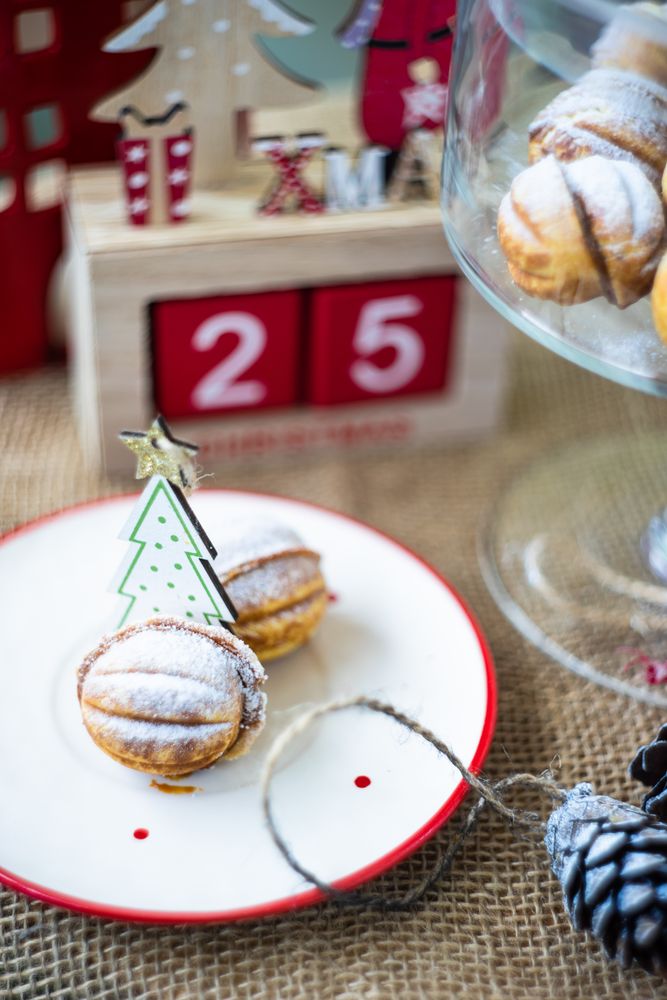 Plate of dessert cookies stuffed with caramel cream surrounded by ornaments
