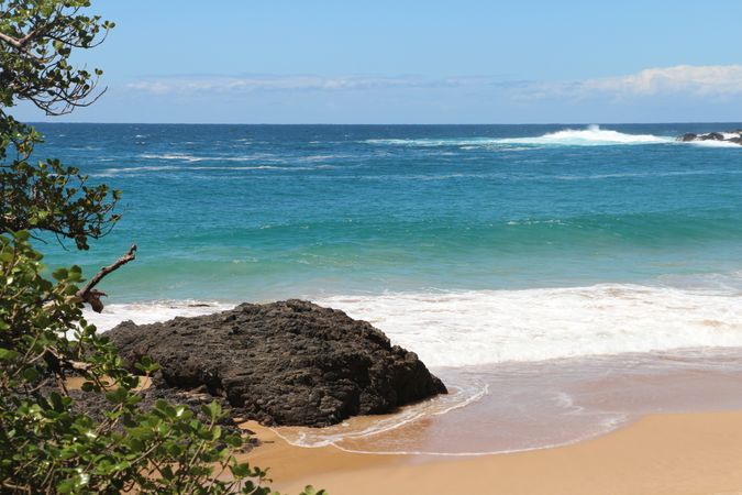 Serene beach landscape with clear turquoise waters and gentle waves on a sunny day