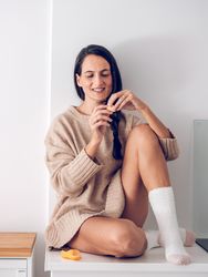 Smiling woman enjoying mandarin at home