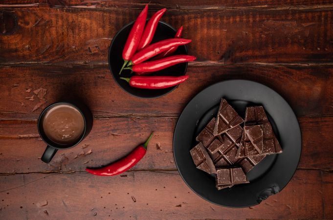 Hot beverage near plate with chocolate and pepper