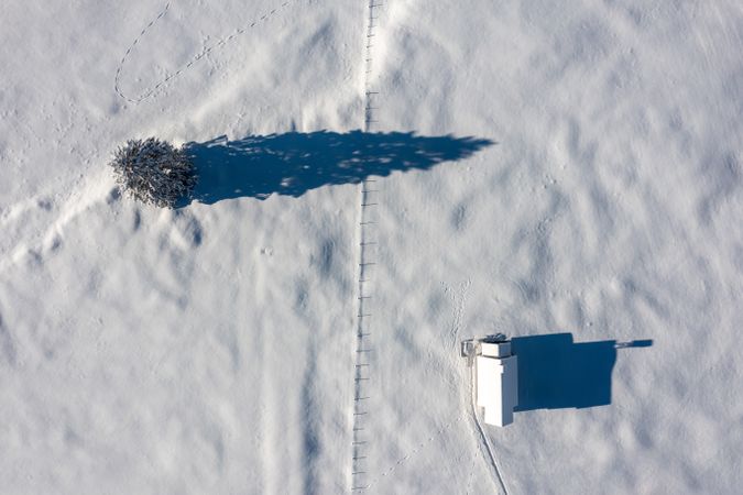 Snowy church minimalist on a snow-covered valley, winter aerial view in the Bavarian Alps, Germany