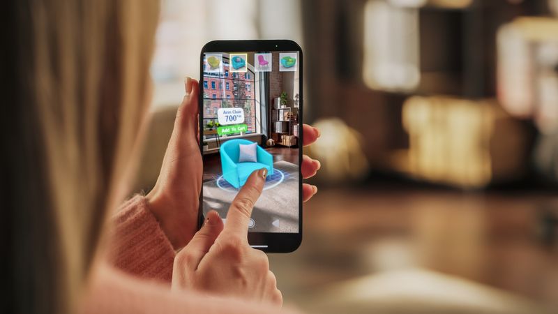 Decorating Apartment: Woman Holding Smartphone, using Augmented Reality Interior Design Software Chooses 3D Furniture for Home.