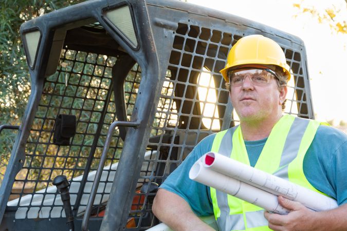 Male Workers With Technical Blueprints at Construction Site