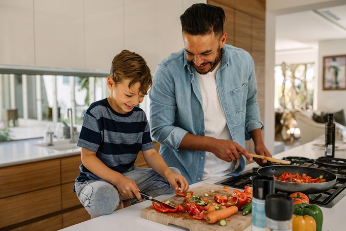 Father and son preparing food at home kitchen