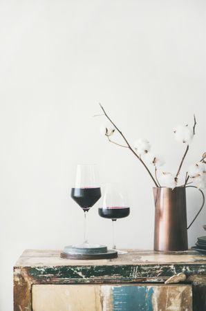 Wine glasses with dried cotton in vase, vertical composition, copy space