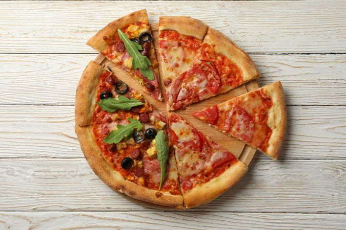 Board with tasty pizza on wooden background