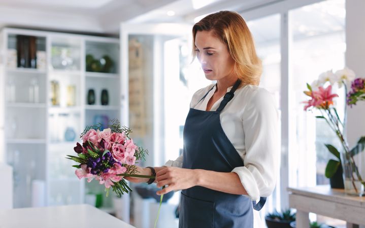 Female florist creating bouquet of flowers at shop