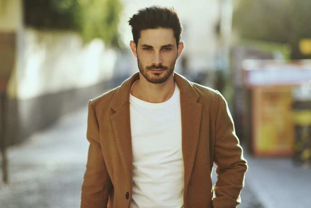 Mid shot of man in smart winter jacket walking on street