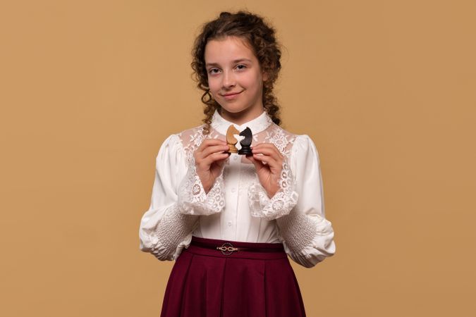 Young girl displaying opposing chess knights