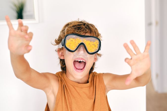 Boy in diving mask with yellow petals yelling at home