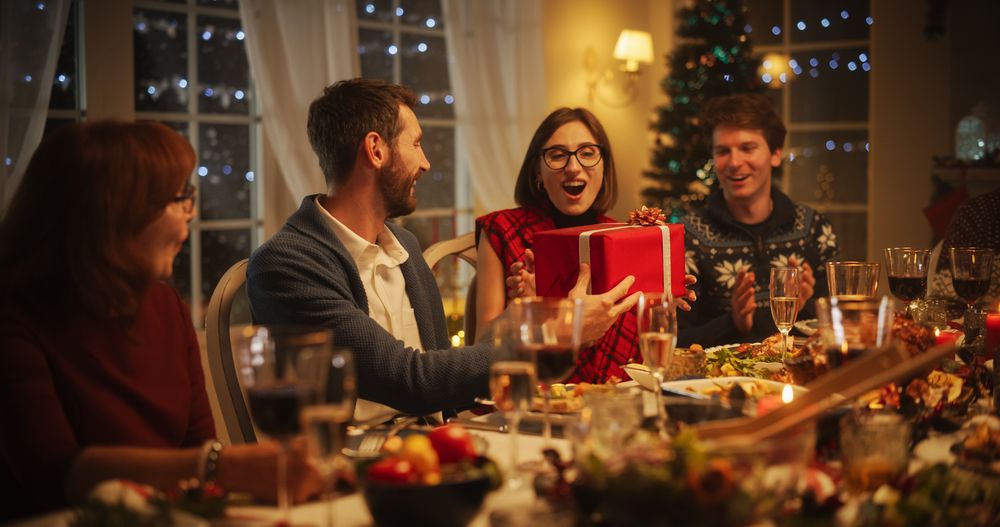 Parents and Relatives Enjoying Christmas Dinner Together in a Cozy Home in the Evening.