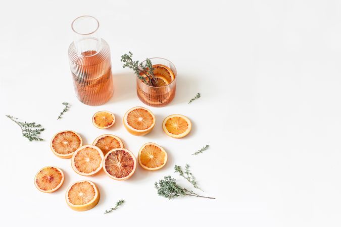 Whole and cut fruits for with thyme herb cocktail isolated on table