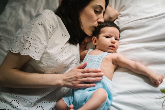 Mother and baby lying on bed