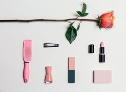 Feminine accessories in pink tones over plain background