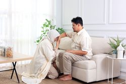 Asian Young Muslim Woman Shake Hand to her Husband Forgiving and Sorry During Hari Raya