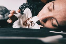 Woman laying beside lily flower