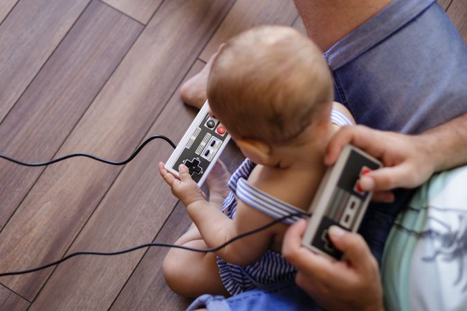 Anonymous father and baby playing video games
