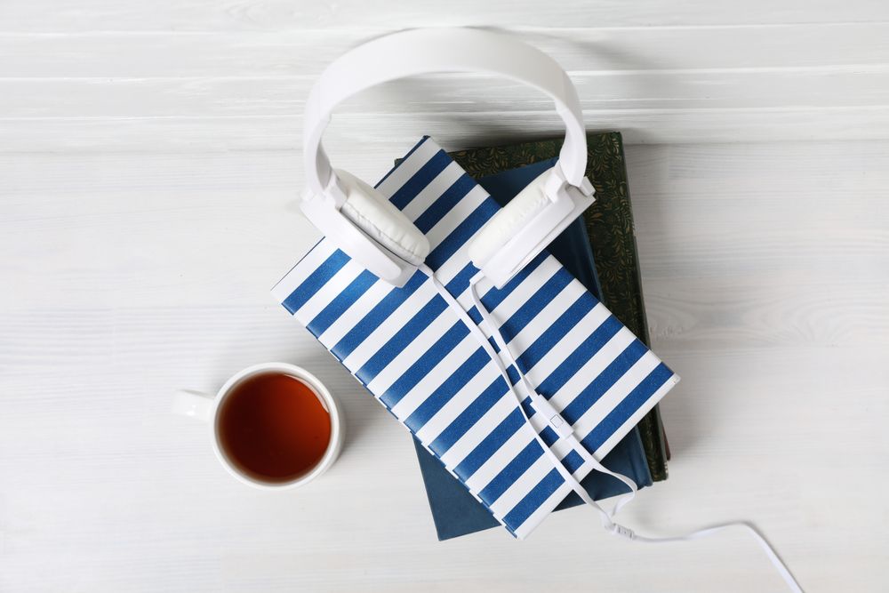 Concept of audiobook with books and headphones, top view